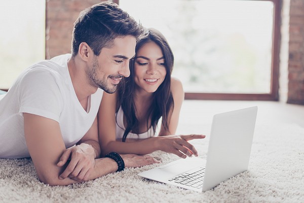 A young couple lounges while looking at the Waldo State Bank website.