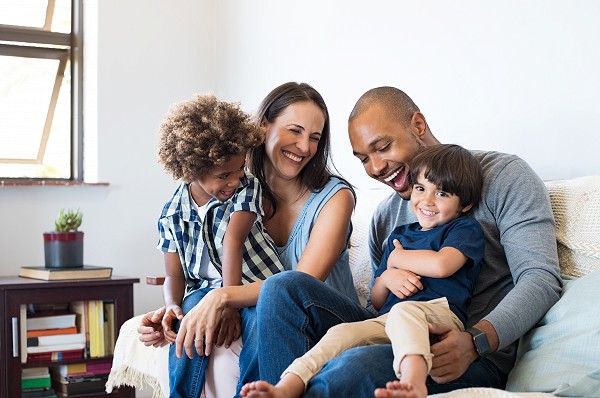 A young family that banks at Waldo State Bank smiles while at their house.