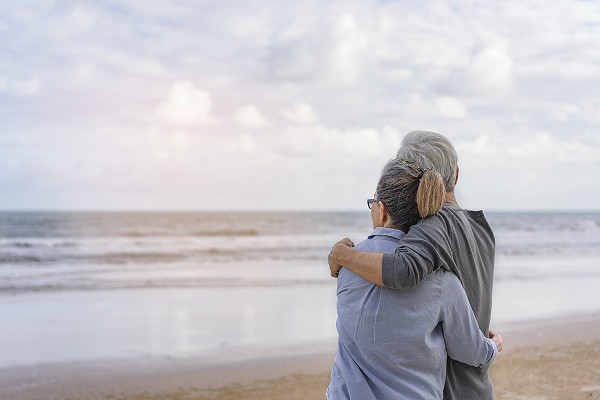 A couple overlooks the ocean.