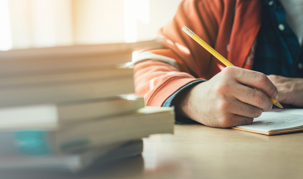 high school,university student study.hands holding pencil writing paper answer sheet.sitting lecture chair taking final exam attending in examination classroom.concept scholarship for education abroad